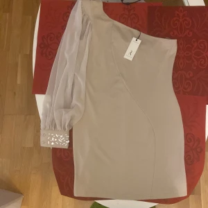 En axel klänning beige  - En axel klänning, beige storlek 42, ny klänning 