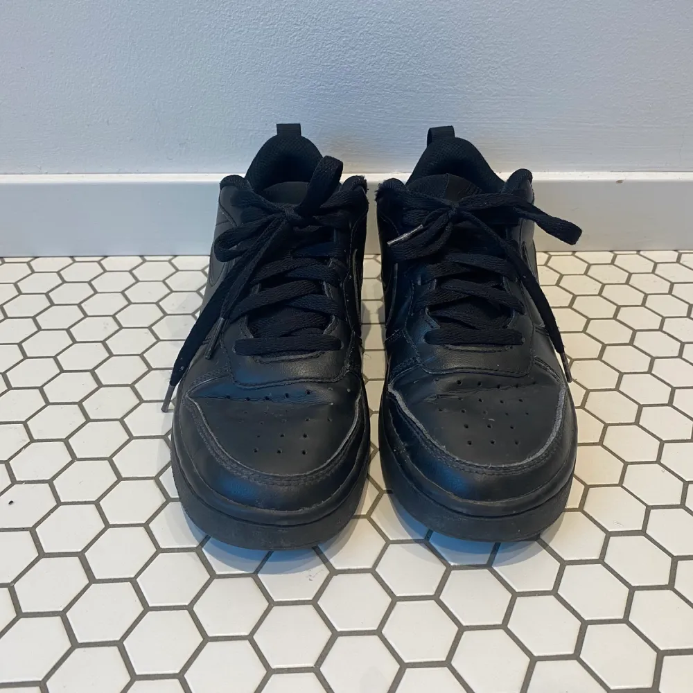 Ett par svarta Nike skor som inte är till användning längre. Dem är i ganska bra skick och inte smutsiga. Väldigt sköna skor att ha till skolan och gå mycket i.. Skor.