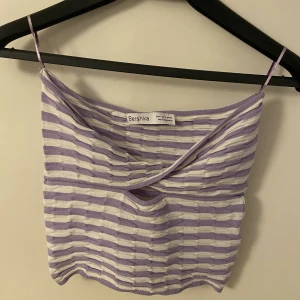 Vit, lila Bershka bandeau topp - En jättesöt bandeau topp i ett lila, vit mönster. Tyget är stretchigt, bara använt 1 gång och är dom ny. Den är i storlek S.