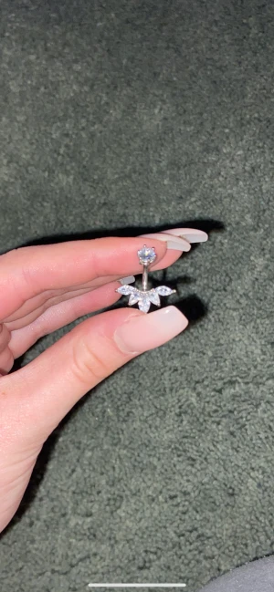 Navelpiercing  - Säljer denna navelpiercing som är helt oanvänd från glitter     Den ör silver impregnerad så tappar därför inte färg eller rostar köpt för 200 kr