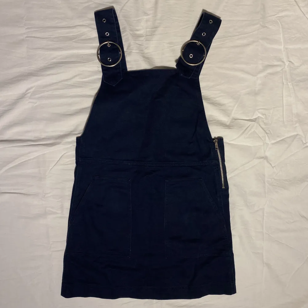 Mörkblå hängselklänning från Monki med dragkedja på sidan samt justerbara band. Har både en i storlek 38 & en i storlek 40, dem kostar båda 90kr/st💗. Klänningar.