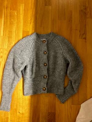 Säljer en grå stickad tröja med knappar från zara, storlek S. Tröjan har större ärmar och sitter snyggt och skönt på! Är i fint skick!