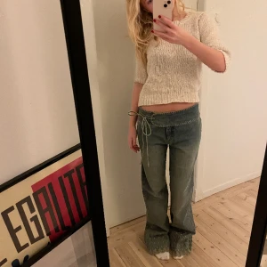 Coola lågmidjade unika jeans - Jätte snygga thriftade jeans från Berlin i en ganska ljusblå färg. Dessa jeans är så coola och unika men är tyvärr för stora för mig! Justerbara med hjälp av snöret i midjan🥰  Skulle säga att de passar någon som är mellan 168-172cm i längd🥰