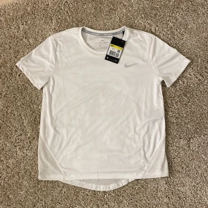 Tränings t-shirt  - Jätte fin vit tränings t-shirt från nike. Säljer då den tyvärr inte passar mig. Den är aldrig använd och har lapparna kvar, alltså helt ny!