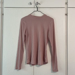 Rosa tröja  - Tröja i tunnt glansigt tyg som är ribbat. Sitter tajt och är bra som ett basplagg. Vet tyvärr ej märke eller storlek men passar medium om man vill ha åtsittande 