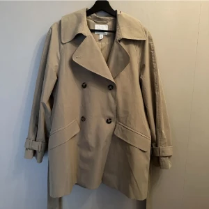 Beige höstjacka - Trenchcoat i lite kortare modell från HM. 