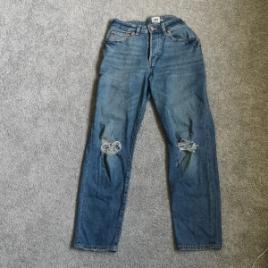 Slitna jeans - Ett par supersnygga jeans som har slitningar vid knäna. Är i nyskick och i momjeans-modellen. I storlek M