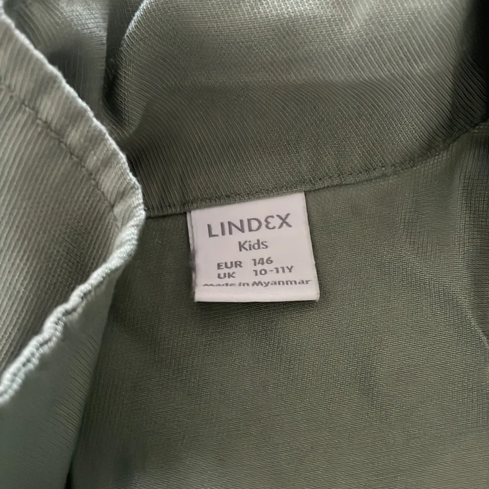 Det är en grön byxdress, den är mjuk och luftig med guldiga knappar och två fickor där fram, två fickor på sidorna, inga bakfickor. Endast använd 1 gång.. Jeans & Byxor.