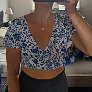 Blommig croptop  - Superfin croptop från hm. Endast använd en gång så är i fint skick. Öppen rygg, knyts baktill. Lappen är bortklippt men skulle säga att det är en S, möjligtvis att den passar även en M då man själv väljer hur hårt man vill knyta