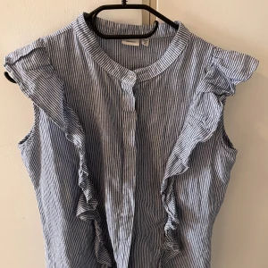 Name it Blus - Säljer min name it blus som är blå/vit randig. En volang på varsin sida av blusen. Skriv för fler bilder!🌷