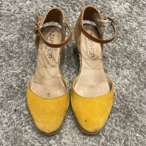 Zapshop med kilklack - Fina kilklacksandaler i senapsgult. Sparsamt använda. Köpta i Madrid på Zapshop