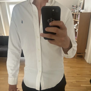Vit Ralph lauren skjorta  - Vit Ralph lauren skjorta som är använd två gånger. Ser ut som ny och kostade 1259kr som ny. Jag har storlek M i vanliga fall och sitter väldigt snyggt på mig. Priset kan diskuteras