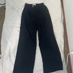 Svarta linnebyxor  - Jag säljer ett par svarta breda linnebyxor från Bershka. Jag säljer dessa då de aldrig kommer till användning och har knappt använt dem. De är högmidjade och är i storlek 32. 