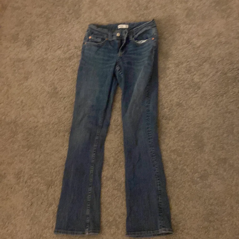 Säljer dessa lågmidjade jeans från Gina med knappar bak på fickorna, väldigt fina men kommer inte till användning så mycket . Jeans & Byxor.