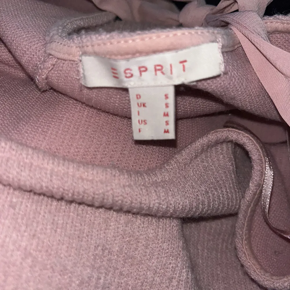 En rosa stickad tröja ish från esprit, skulle säga storlek M, men passar S om man vill ha oversized. Det är en rosett på baksidan. . Stickat.
