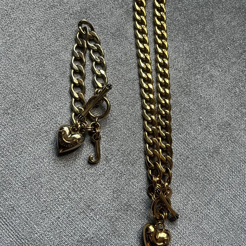 Fint smyckesset från Juicy Couture med ett  guldfärgat armband och halsband i fint skick.   Hämtas på Kungsholmen och betalas med Swish, vid frågor är det bara att höra av sig. . Accessoarer.