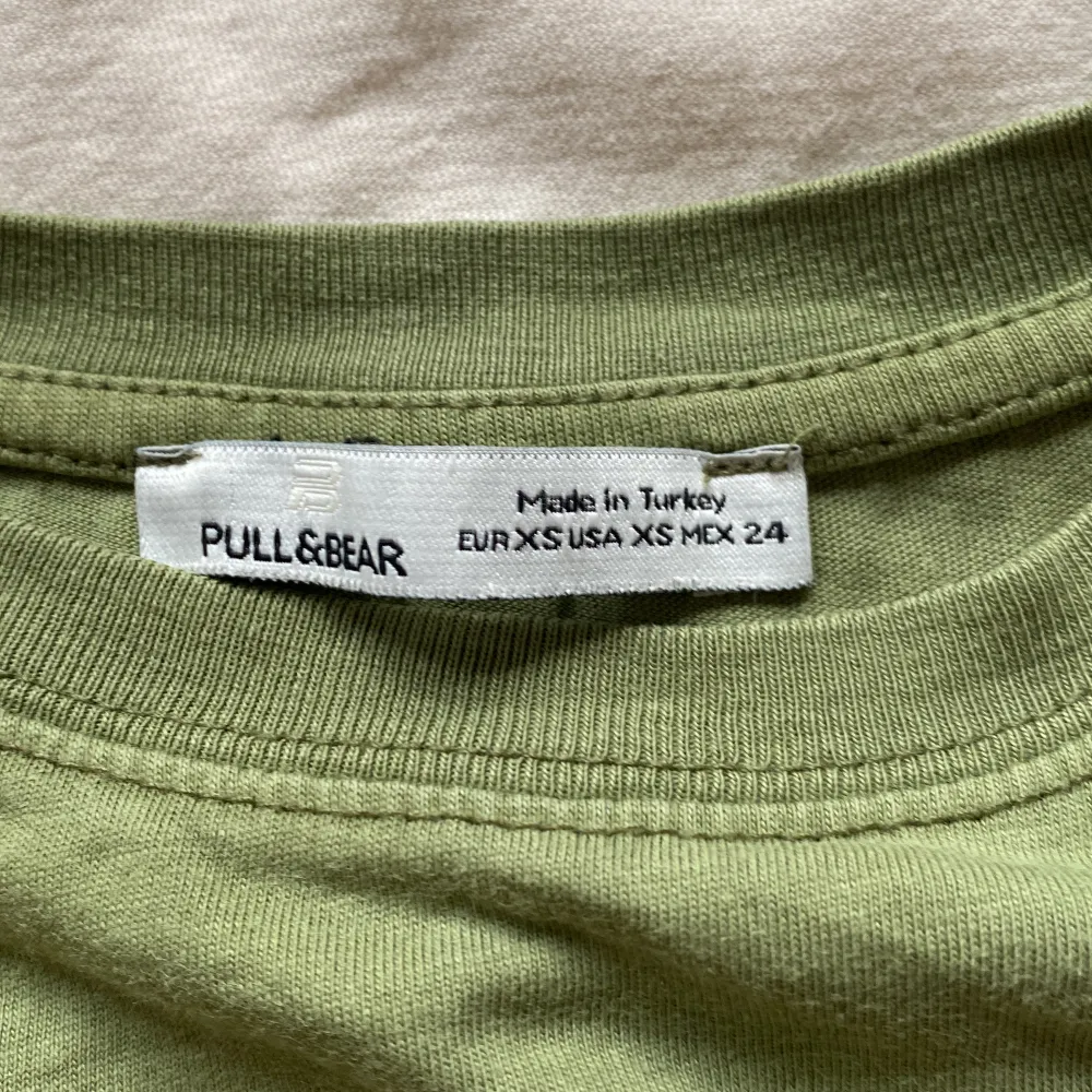 En grön T-shirt köpt från PULL&BEAR för 200kr säljer för 100kr. Storlek Xs. Säljer för att den inte kommer till användning.. T-shirts.