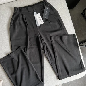 Kostymbyxor - Svarta kostymbyxor med resår i  midjan, långa ben(!!) aldrig använda