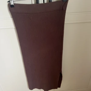 Brun kjol - Brun ribbad kjol med slits nedtill. Väldigt fin och skön på. Storlek S