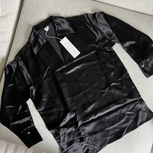 Arket satin blus - Svart blus från Arket i satinaktigt material, aldrig använd, strl  34 men passar 36