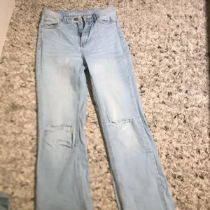 Bootcut jeans  - Fina blåa bootcut jeans med hål på knäna det är väldigt fint skick!