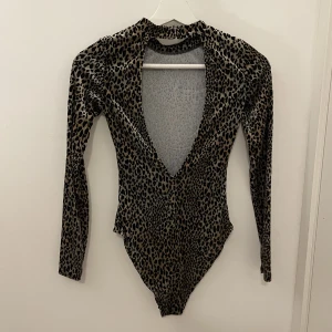 Body  -   En trendig animal print body i storlek XS, som har används endast några få gånger. Materialet är mjukt och behagligt att bära. Bodyn är i utmärkt skick och ger en modemedveten touch till din outf
