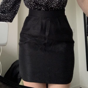 Kort kjol - Svart kort kjol. Fickor på vardera sida. Högmidjad. Dragkedja där bak.  Jättefint skick! 