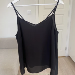 Svart linne  - Tunnt svart linne med justerbara band och v urringning i storlek 44.