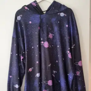 Mysig hoodie med galaxytema. Köpte den för några år sedan men har knappt använt den. Rätt stor i storleken. Ficka och luva 