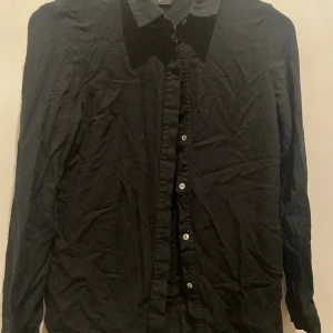 Svart skjorta - Skjortan kommer inte till användning behöver en ny ägare. Den är i bra skick och inga fläckar 