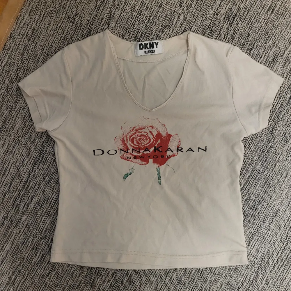 Ljusbeige tshirt från DKNYmed tryck och test i storlek S.. T-shirts.