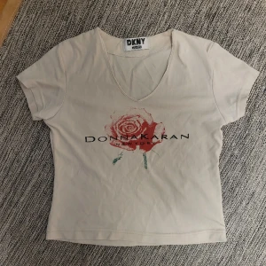 Tshirt - Ljusbeige tshirt från DKNY med tryck och test i storlek S.