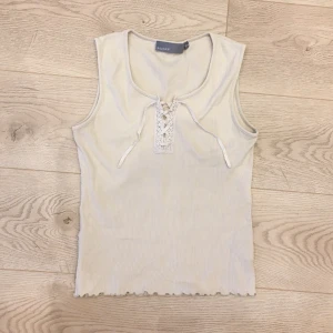 Ribbat linne - Ribbat bredaxlat linne med rund halsringning och snörning fram. Köpt nån gång på tidigt 2000-tal. 