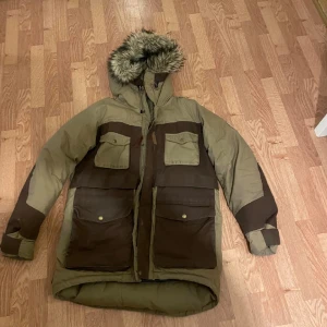 Fjällräven parker g-1000  - Hej detta är en fjällräven parker med g-1000 matrial som måste behandlas med vax varje år ,dock måste jackan tvättas innan dess, obs det finns små skador på jackan men inget märkvärdigt 