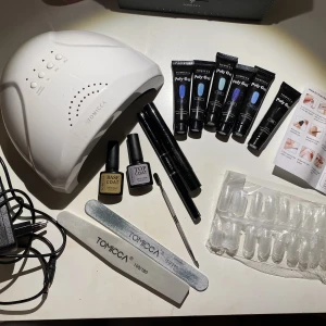 Polygel set - Polygel set där UV/led lampa, naglefilar, andra verktyg, 5 remsor med olika former, top och base coat samt 5 olika blåa nyanser samt 1 svart av polygel ingår. Endast använd en gång och säljer pga aldrig använder. Från TOMICCA. 