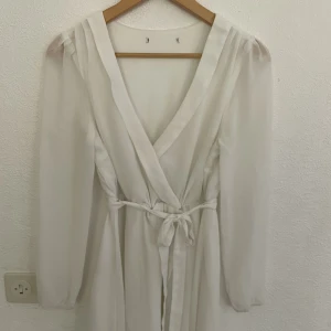 Klänning - Vit klänning som köpt till en student. Använd en gång. Oklart från vilket märke då lappen är bortklippt.