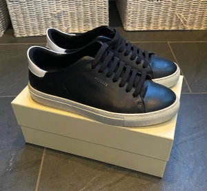 Axel Arigato skor - Säljer mina gamla Axel arigato skor. Bra skick. Färg svart. Men vit kontrast. Kommer med allt og. 