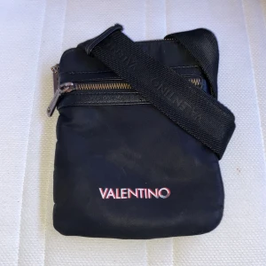 Axelväska  - En smal valentino axelväska köptes från Valentin original hemsida för 1 och ett halv år sen. Men är fortfarande i bra skick o inget fel med den. 