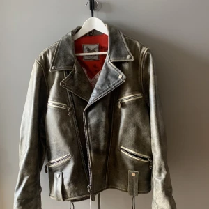 Flying Eagle Läderjacka - Vintage bikerjacka av märket Flying Eagle. Prislappen kvar men köpt vintage. Storlek L så beroende på önskad passform skulle jag säga att den passar storlek M-XL. Färgen är svart/brun. 