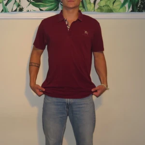 Burberry Piké  - Tja, säljer denna snygg piké från Burberry! Den är en tunnare modell vilket är skönt då den luftar mycket!  Storleken är L men sitter som M! Con 7/10 den är i mycket bra skick utom 1 litet hål(se bild.3) Hör gärna av dig vid fler frågor🙏