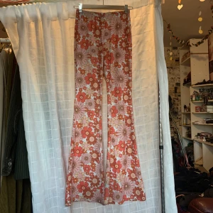 Blommig bootcut  - Blommiga bootcut byxor me tunt material o stretchigt. Använda få gånger för 1 år sen