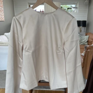 Tröja i satinmaterial - Fin tröja, champangevit färg i satinmaterial, aldrig använd då den var för tajt för mig runt brösten! Strl. 36