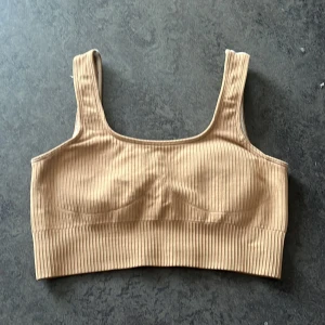 Aim’n Sport BH S - Sport-BH i ribbat material. Djup rygg. Beige/natur färgad Aim’n  Storlek: 36/S  Sparsamt använd! 