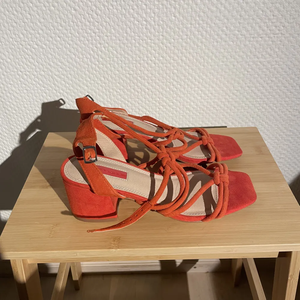 Helt oanvända sandaletter i en superfin orangeröd färg. Passar dig som har en smal/liten 36a.   I äkta mocka! . Skor.