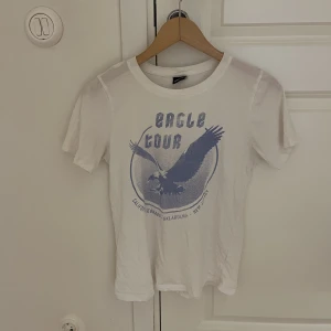 T-shirt  - Vit T-shirt med blått motiv. Fint skick.