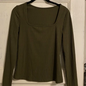 Långärmad T-shirt  - Långärmad grön t-shirt i glansigt material. Aldrig använd.