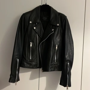 Äkta skinnjacka - En supersnygg klassisk skinnjacka i äkta skinn. Storleken är M men skulle nog mer säga att den passar en S eller XS om man vill att den ska vara mer oversize. Jackan har tjockare tyg och en innerficka. Knappt använd! Köparen står för frakten ☺️