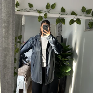 Regnjacka  - Regnjacka som ny, lite lite sminkmärke vid krage som förmodligen går bort. 