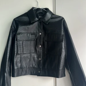 Skinnjacka  - I princip oanvänd fake-skinn jacka från Gina -tricot.  Jackan är lite kortare i modellen. Jackan är storlek L men passar mig som är M.