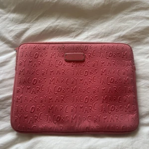 Datorfodral  - Datorfodral från Marc by Marc Jacobs i corall. Passar standard MacBook. Använd men i fint skick!